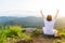 Back side young girl making two finger fleeing freedom on top of mountain