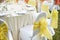 Back of spandex white cover chairs yellow organza sash for wedding reception dinner table