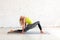 Back stretch and hip joint mobility. Caucasian woman practice yoga in deep lunge on a mat in loft white studio indoor