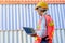 The back of technician woman work with laptop and stand in front of cargo containers with day light