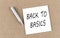 BACK TO BASICS text on sticky note on cork board with pencil