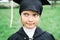 Back to elementary school concept. Little girl goes to first grade. Ceremony of graduating. Black gown, academic cap