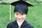 Back to elementary school concept. Little girl goes to first grade. Ceremony of graduating. Black gown, academic cap with tassels