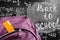 Back to school background with purple school bag with yellow ruler and the title `Back to school` and math formulas