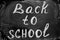 Back to school background with title `Back to school` written by white chalk on the black chalkboard.