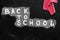 Back to school background with title `Back to school` written by white chalk on the black chalkboard and rag for erasing