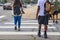 Back to school - the backs of college students crossing urban crosswalk with backpacks - ethnic diversity and casual dress with ca