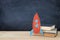 Back to school banner. Painted cardboard rocket next to books in front of classroom blackboard.