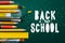 Back to school banner, with school items and elements on green chalkboard background, vector illustration.