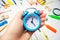 Back to school. blue alarm clock on the school desk in the hands of a student. stationery. accessories. White background. stickers