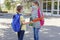 Back to school. Brother and sister or boy and girl wearing protective medical masks in the schoolyard. Distance in a pandemic.