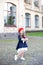 Back to school. Child education and school concept. Little girl in a red beret holds a stack of books with an apple on the street.