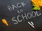 Back to school concept. Black chalkboard with pieces of chalks and autumn yelllow leaves  on white background. Flat lay