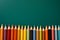 Back to school concept with bright pencils on a green chalkboard background