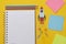 Back to school concept. Colorful rocket, open notebook, school supplies. Yellow background. Flat lay, top view. Copy space