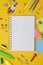 Back to school concept. Colorful rocket, open notebook, school supplies. Yellow background. Flat lay, top view. Copy space