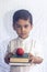 Back to school concept. Cute middle eastern boy holding a stack of books against the white background. Portrait of Central Asian