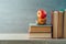 Back to school concept with school bus toy, apple and books on wooden shelf background