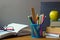 Back to school concept, school supplies, stack of books, chalk board and open book with glasses on a wooden surface, selective