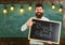 Back to school concept. Teacher in eyeglasses holds blackboard with inscription back to school. Man with beard and