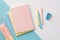 Back to school concept. Top view photo of colorful school supplies stack of copybooks pens mini stapler and pink pencil-case on