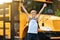 Back To School. Happy Boy Jumping Near Shool Bus And Raising Hands