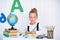 Back to school. Happy smiling pupil at the desk. Child in the cl