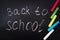 Back to school message on Blackboard inscribed with colorful chalk for background.