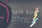 Back to school message on Blackboard inscribed with colorful chalk for background. Backpack.