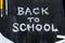 Back To School phrase written on a black wood background.