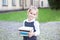 Back to school. Portrait of a schoolgirl with books, textbooks on the background of the school. Education concept. Preschool educa