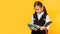 Back to school. Portrait of a schoolgirl with a schoolbag and books. Yellow Studio background. School Education Concept