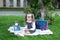 Back to school. schoolgirl with glasses holds a magnifying glass. A little girl sits on the grass near the school with books, a sc