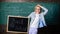 Back to school special offer. Woman teacher holds blackboard back to school inscription on chalkboard background. Apply