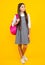 Back to school. Teenager school girl in school uniform with bagpack. School children on isolated studio background.