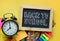 Back to School Text. Alarm Clock, Blackboard and School Stationary on Yellow Background