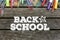 Back to School text on wooden background with school supplies