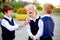Back to school: three school children boys and a girl wearing uniform playing and laughing