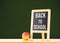 Back to school word on blackboard on wood table with apple at gr
