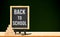 Back to school word on blackboard on wood table with pyramid cub