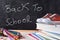 Back to school written on blackboard and tools front