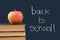 Back to school written on chalkboard wiith apple,