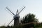 Back of a traditional windmill wind pump amidst trees and bushes