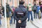 Back of a uniformed policeman among the people on the street