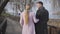 Back view of adult Caucasian man and woman in elegant coats walking in park. Positive married couple enjoying sunny