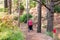 Back view Alone Disabled aged female person with walker during her walk in the forest, park. Selective focus, copy space