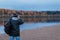 Back view of amateur photographer shooting the autumn scenery of the river. Landscape therapy