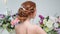 Back view of amazing young bride. Red head woman seat on the chair. Elegant hairstyle.