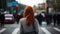 Back view of anonymous female with red hair standing near crosswalk