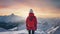 back view of an anonymous woman person high in the snowy mountains in winter at sunset in a cloudy sky